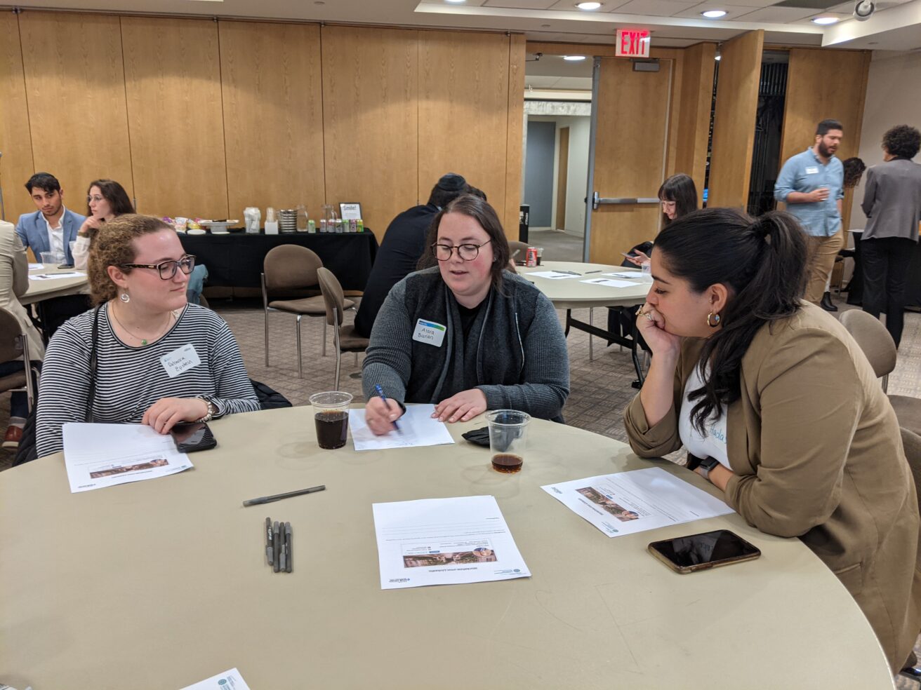 A group of CUNY Hillel members sitting around a table with papers.