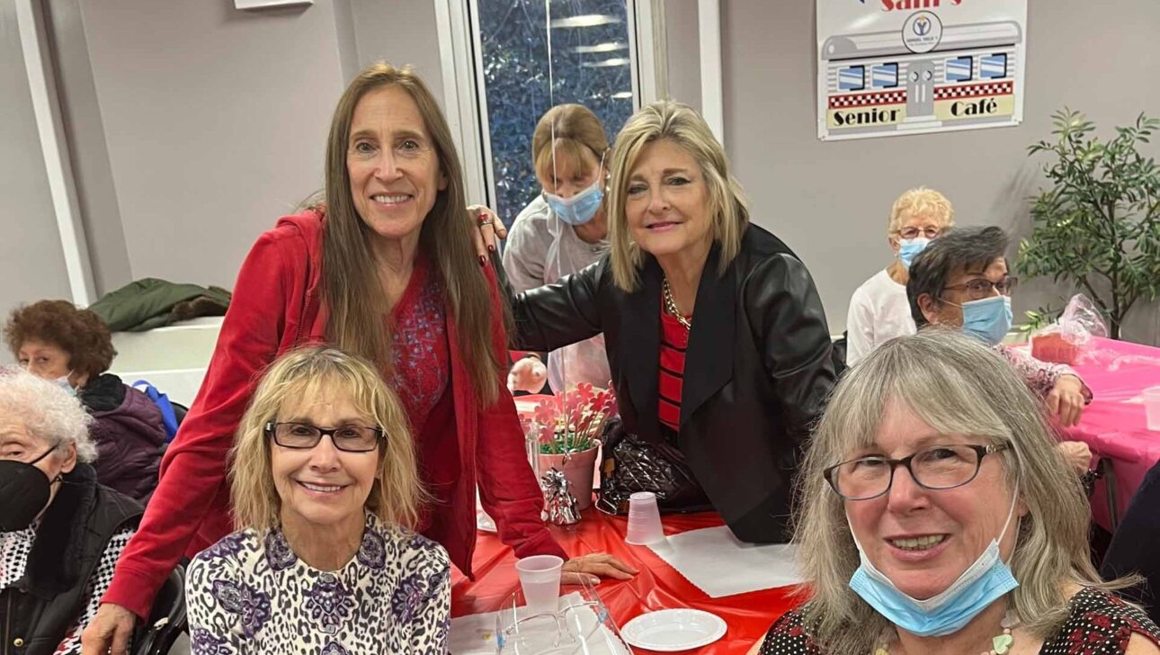 A group of women posing for a photo at a table.