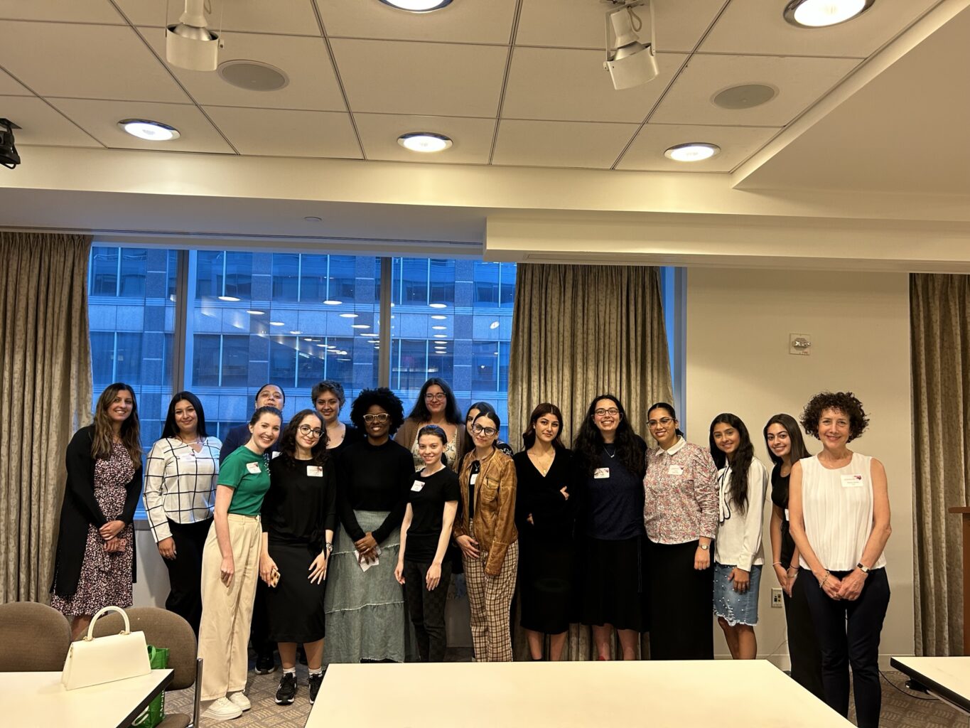 A group of women posing for a picture in a conference room while creating an Auto Draft.