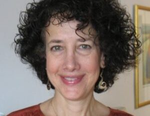 A woman with curly hair smiling for the camera.