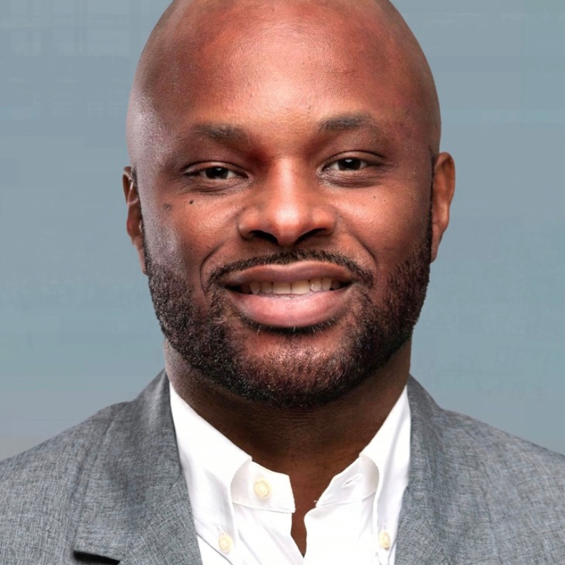 Gavin Johnston, a black man, dressed in a gray suit and white shirt.